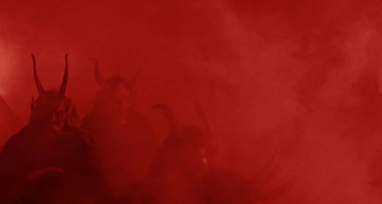 Horned, demonic figures shrouded in red smoke, still from the short film Ember